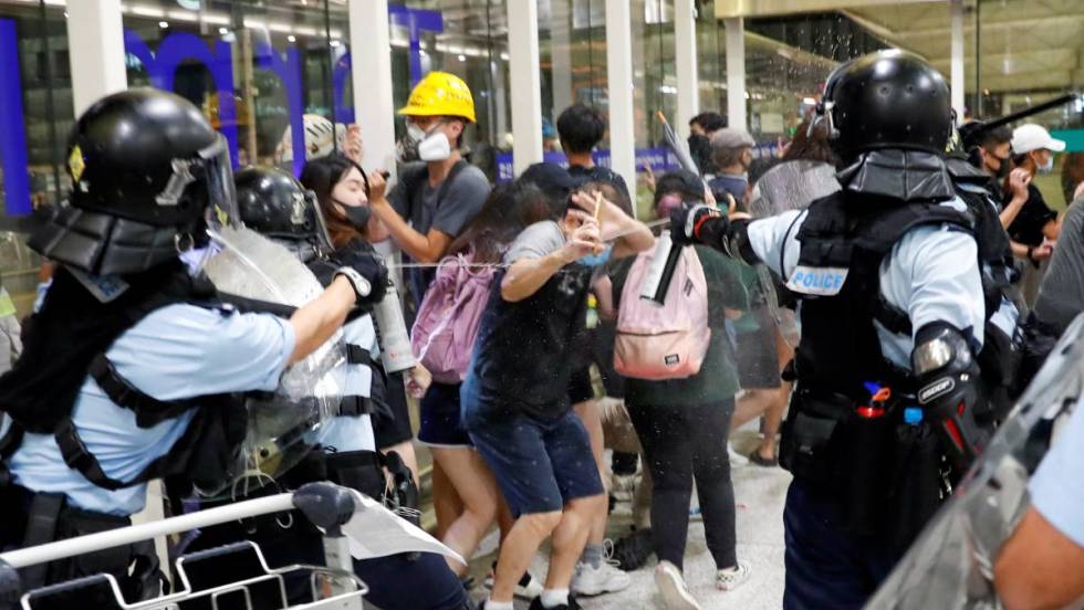 La policía carga contra los manifestantes en el aeropuerto de Hong Kong el segundo día de bloqueo
