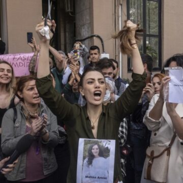 Una mujer iraní reacciona cortándose el pelo en una protesta frente a la embajada iraní en Estambul (Turkía), con una foto de Masha Amini en el pecho. — ERDEM SAHIN / EFE/EPA