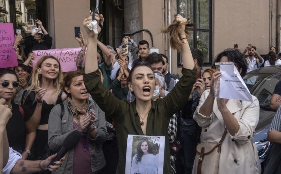 Una mujer iraní reacciona cortándose el pelo en una protesta frente a la embajada iraní en Estambul (Turkía), con una foto de Masha Amini en el pecho. — ERDEM SAHIN / EFE/EPA